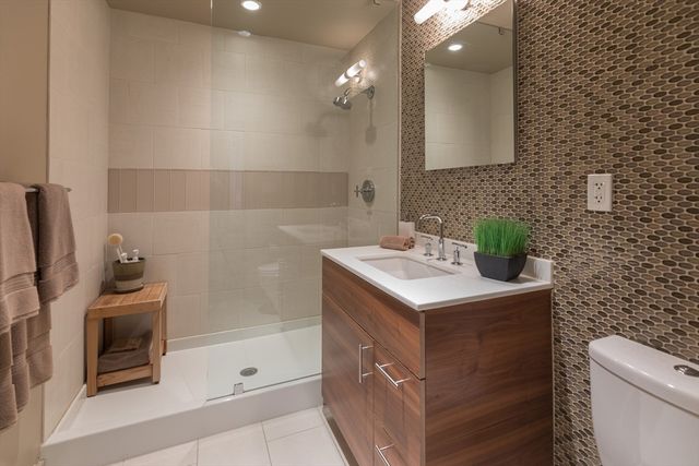 a bathroom with a sink a toilet and shower