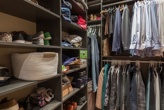 a view of walk in closet with clothes and shoes
