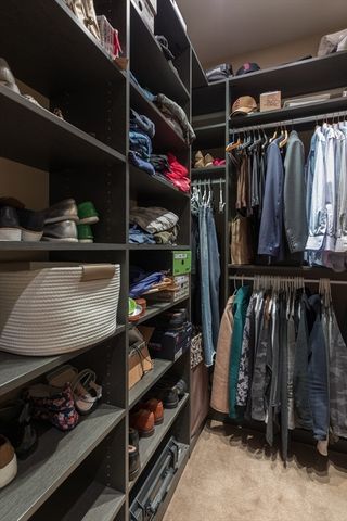 a view of walk in closet with clothes and shoes