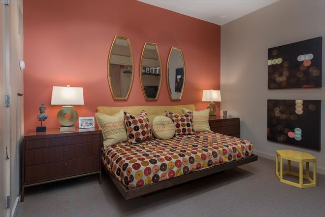 a bedroom with a bed and lamp on dresser