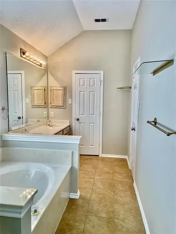 a bathroom with a tub a sink and a mirror
