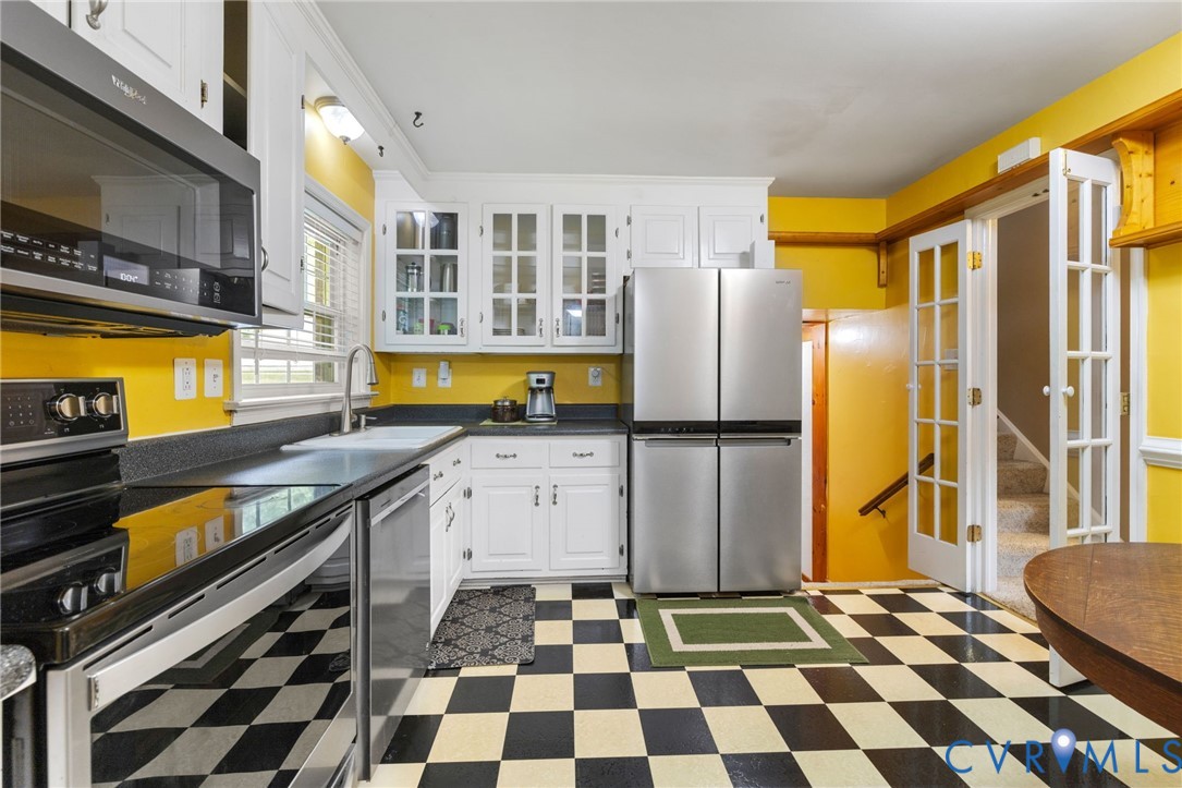 Kitchen with stainless steel appliances, dark floo