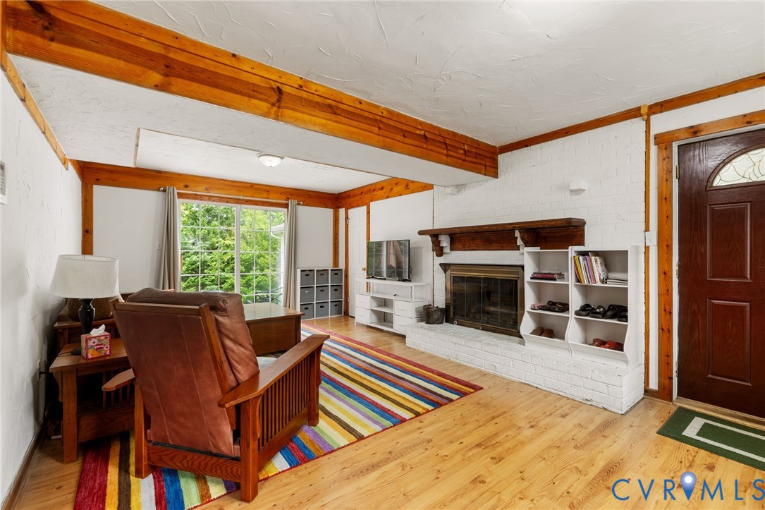 Living area with a fireplace, light wood-style flo