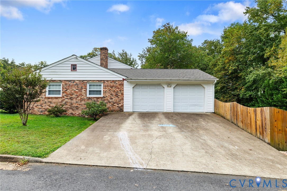 Ranch-style home featuring a chimney, driveway, br