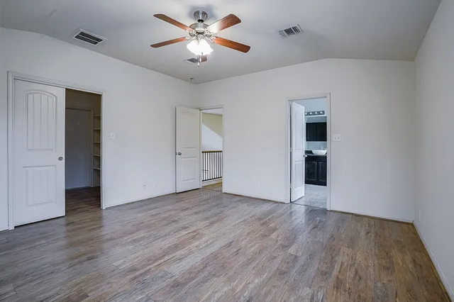 a view of an empty room with wooden floor