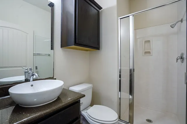 a bathroom with a sink a toilet and shower