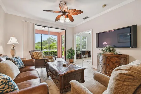 a living room with furniture a large window and a flat screen tv