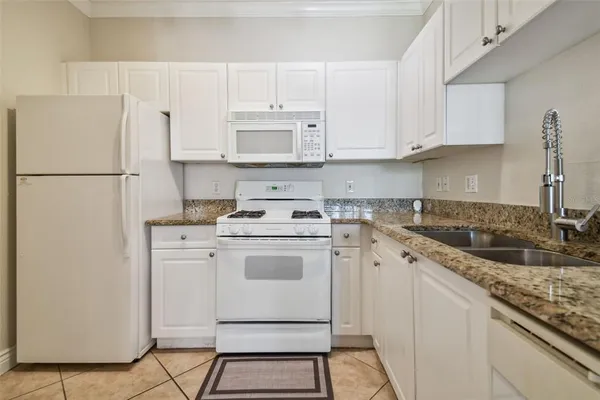 a kitchen with appliances a sink and cabinets