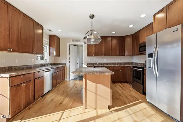 a kitchen with stainless steel appliances granite countertop wooden cabinets a sink and dishwasher
