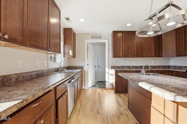 a kitchen with granite countertop a refrigerator and a stove top oven