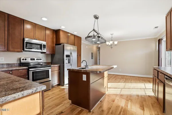 a kitchen with stainless steel appliances granite countertop a sink stove and refrigerator