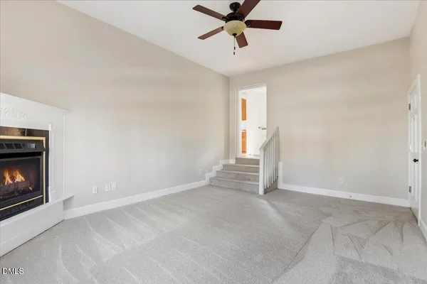 a view of an empty room with a window and fireplace