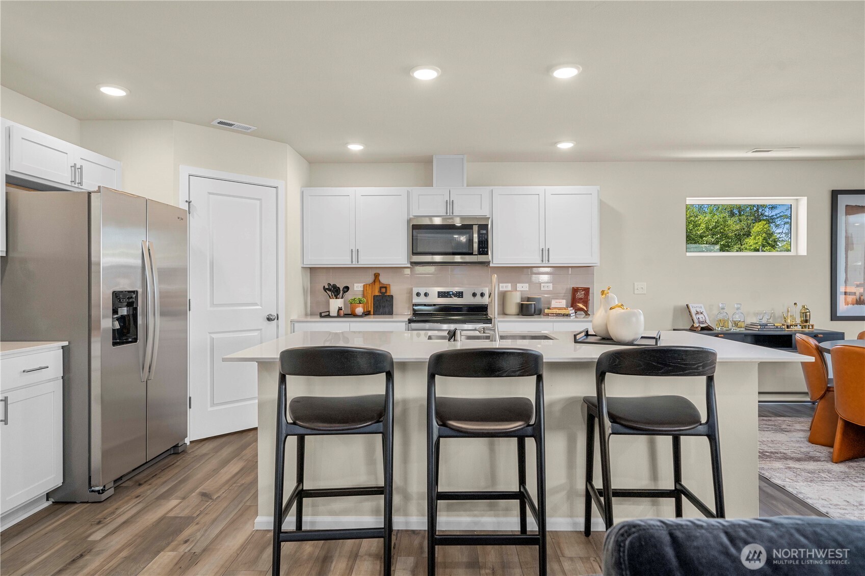 13430 323rd Avenue Southeast Sultan, WA 98294 - Photo 14 of 36 a kitchen with stainless steel appliances granite countertop a refrigerator a stove a sink a dining table and chairs with wooden floor
