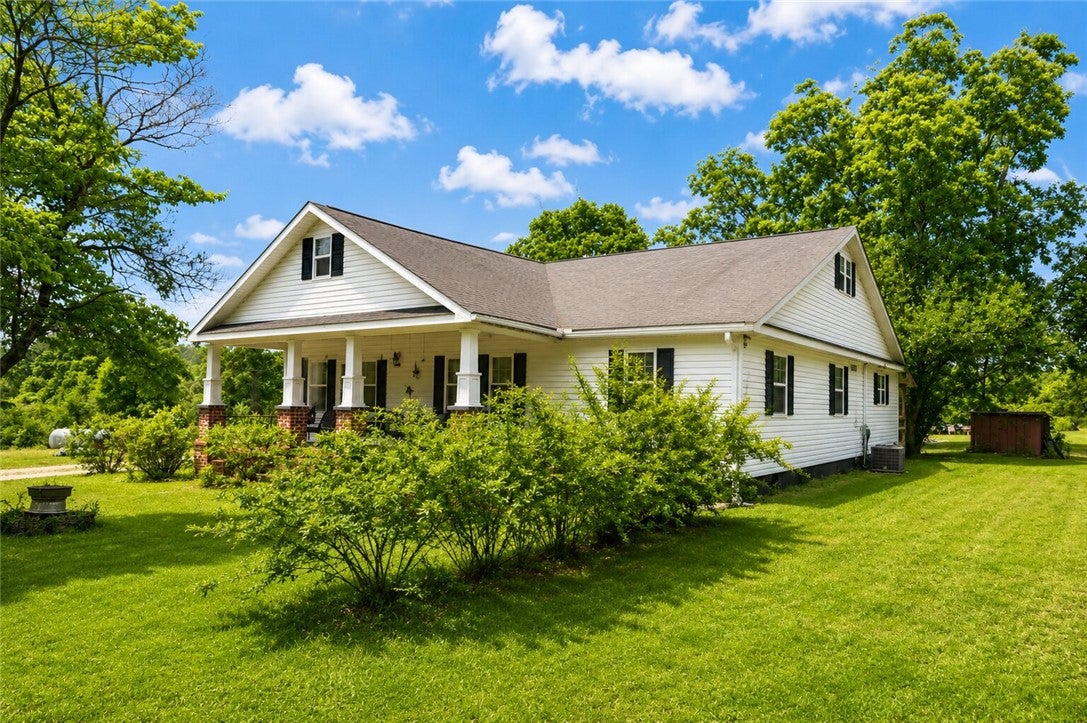 1075 Lowe Road Notasulga, AL 36866 - Photo 5 of 16 This charming home features a welcoming porch, lush green lawn, and mature trees for serene outdoor living.