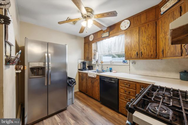 a kitchen with stainless steel appliances granite countertop a sink a stove and refrigerator