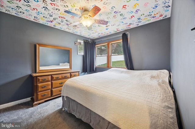 a bedroom with a bed and a flat tv screen on dresser
