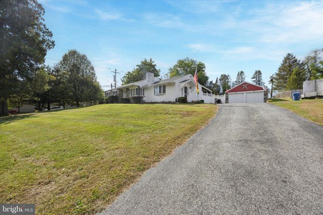 a front view of house with yard and trees in the background