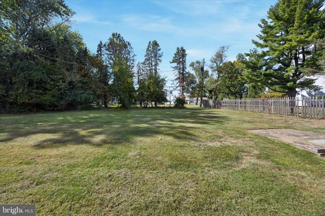 a view of a green field with trees in the background