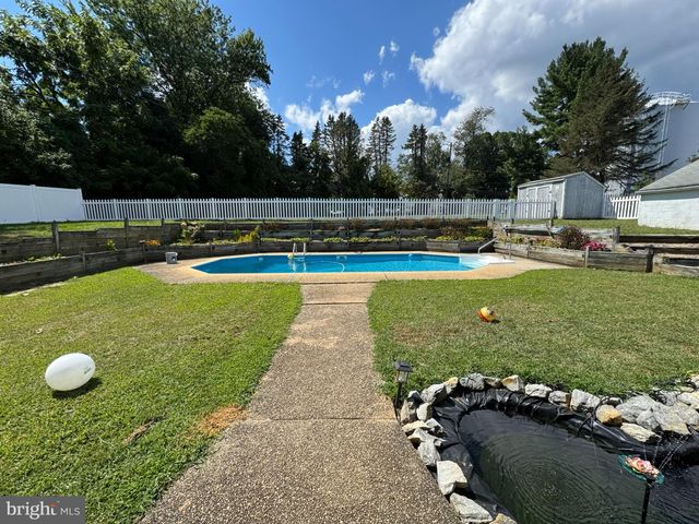 a view of a house with swimming pool and yard