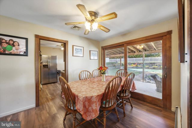 a dining room with furniture a chandelier and wooden floor