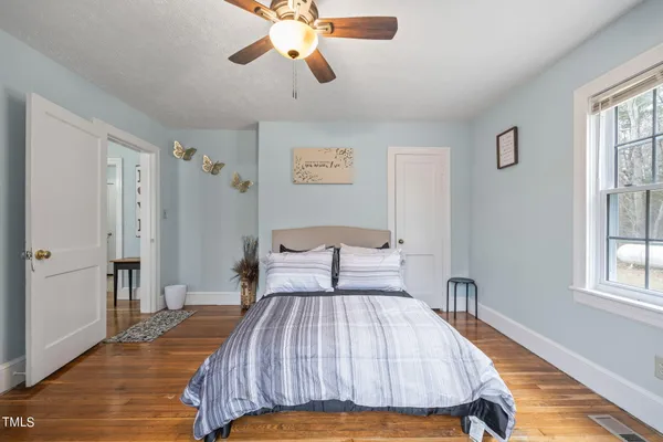 a bedroom with a bed and wooden floor