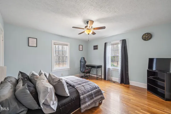 a bedroom with a bed and wooden floor