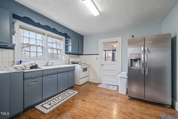 a kitchen with a refrigerator sink and cabinets