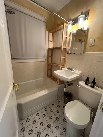 a bathroom with a sink a toilet a mirror and shower