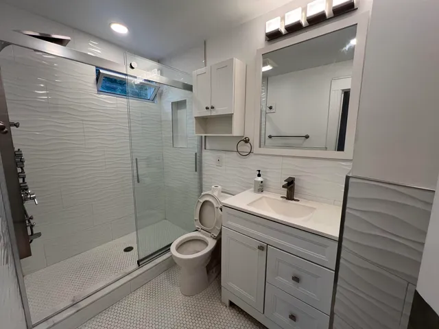 a bathroom with a sink a toilet and shower