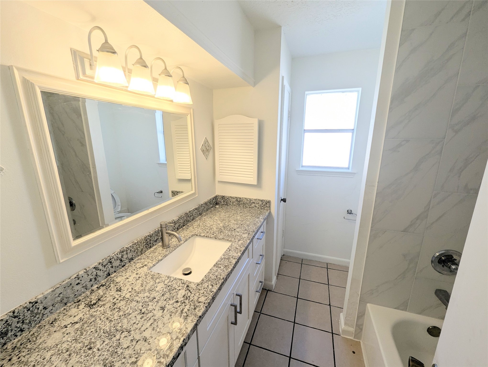 17602 Crestline Road Humble, TX 77396 - Photo 15 of 27 a bathroom with a granite countertop sink and a mirror