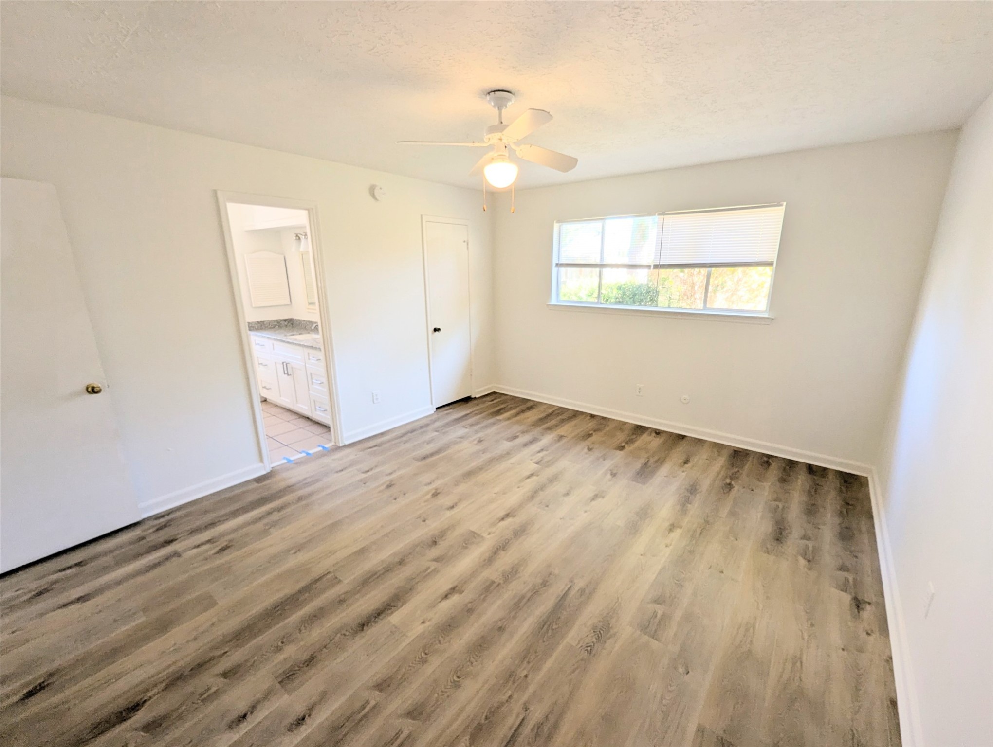 17602 Crestline Road Humble, TX 77396 - Photo 21 of 27 an empty room with wooden floor cabinet and windows