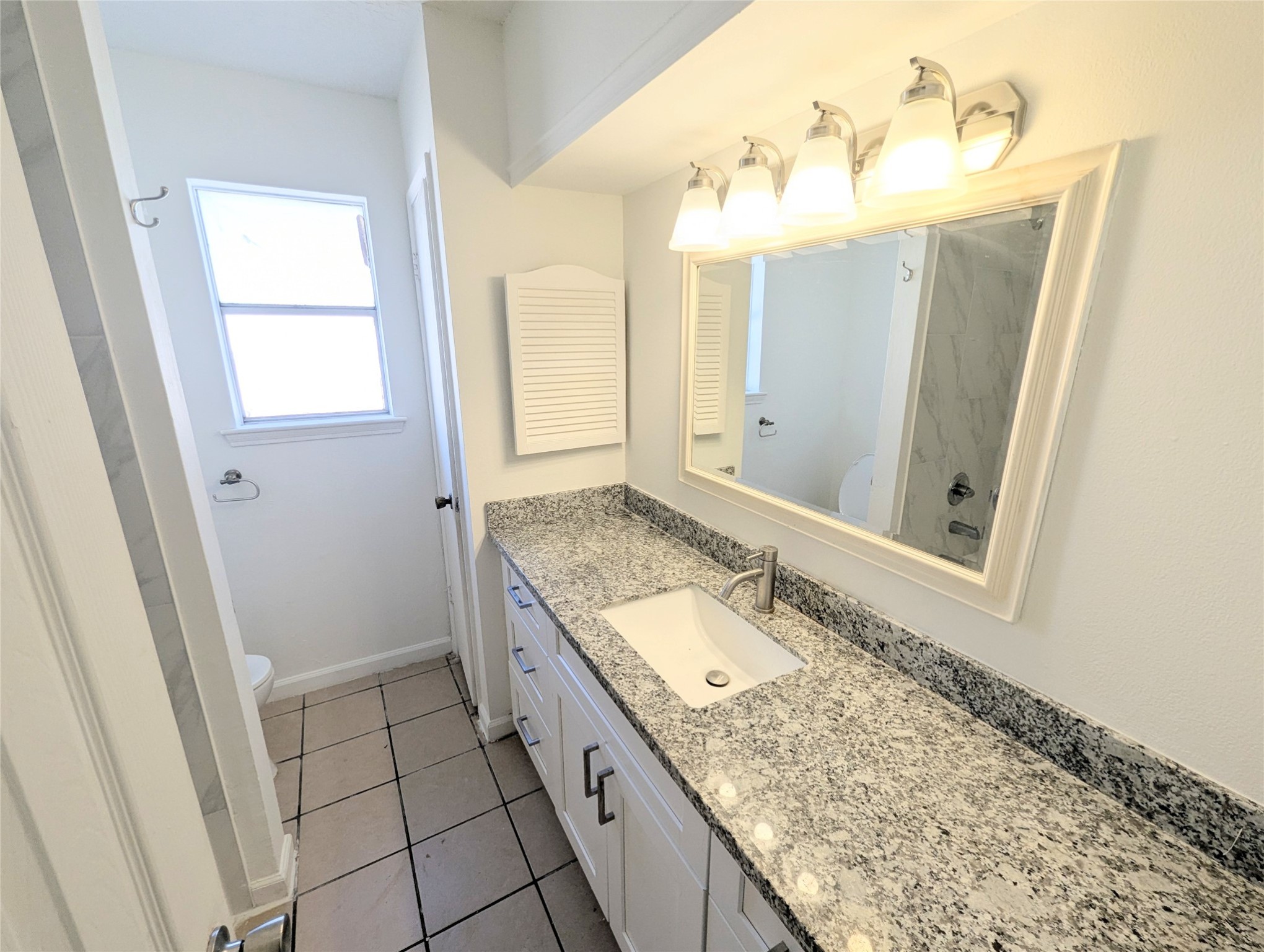 17602 Crestline Road Humble, TX 77396 - Photo 23 of 27 a bathroom with a granite countertop sink and a mirror