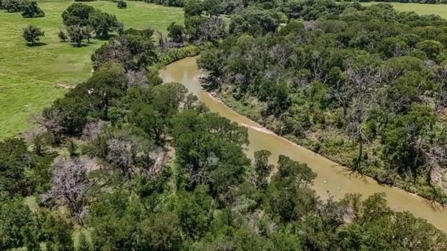 an aerial view of a house with a yard and lake view