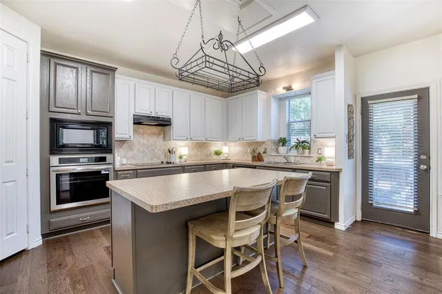 a kitchen with kitchen island granite countertop a sink counter and stainless steel appliances