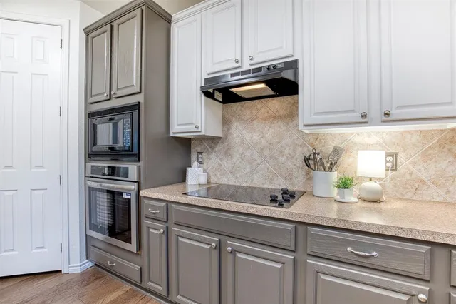 a kitchen with stainless steel appliances granite countertop a sink a stove and cabinets