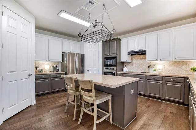 a kitchen with kitchen island granite countertop stainless steel appliances cabinets a sink and a center island