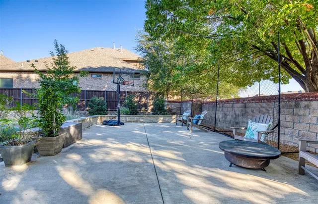 a view of a backyard with potted plants and large tree