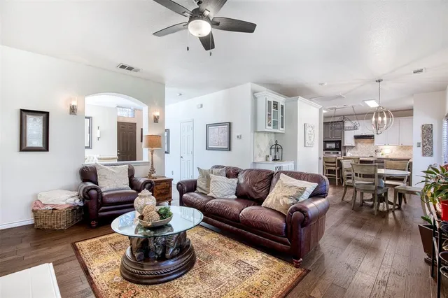 a living room with furniture kitchen and a chandelier