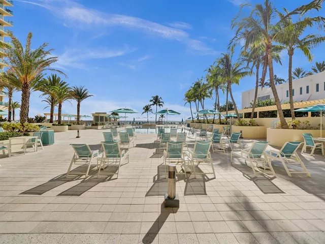 a view of a swimming pool with outdoor seating and plants