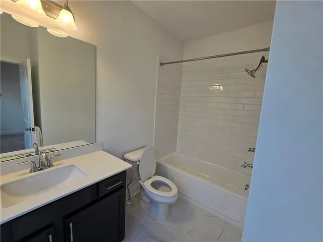 a bathroom with a granite countertop sink toilet a mirror and shower