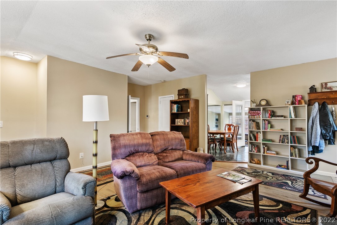 628 Tc Jones Road Raeford, NC 28376 - Photo 11 of 46 a living room with furniture a ceiling fan and a bookshelf