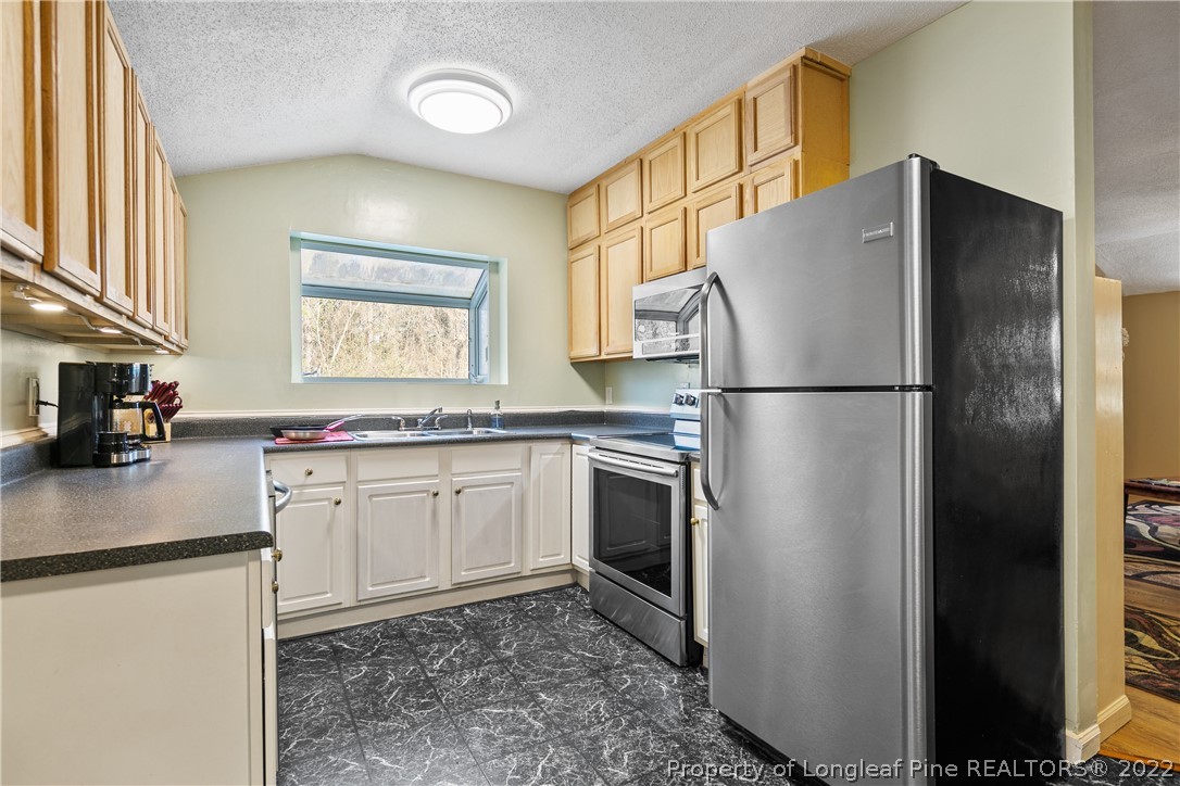 628 Tc Jones Road Raeford, NC 28376 - Photo 15 of 46 a kitchen with stainless steel appliances granite countertop a refrigerator a stove a sink and a microwave