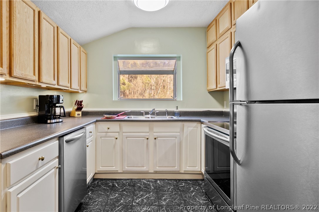 628 Tc Jones Road Raeford, NC 28376 - Photo 16 of 46 a kitchen with stainless steel appliances granite countertop a sink a stove a refrigerator and cabinets