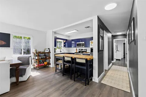 a living room with stainless steel appliances a kitchen island furniture and a kitchen view