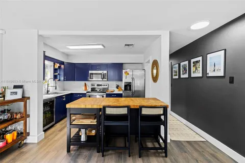 a kitchen with stainless steel appliances sink stove and wooden floor