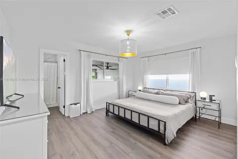 a bedroom with bed and flat screen tv