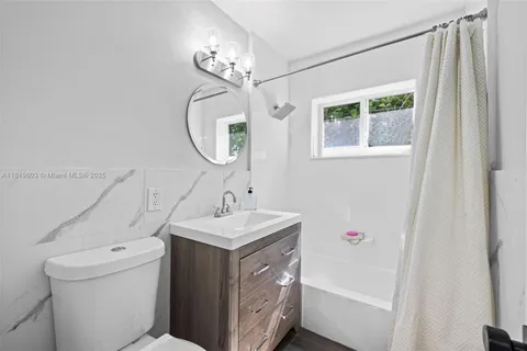 a utility room with dryer and wooden floor