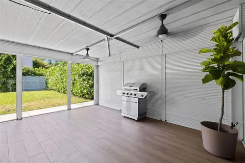 a view of a livingroom with a potted plant a ceiling fan and wooden floor