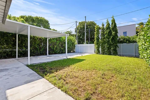 a view of a house with a yard and sitting area