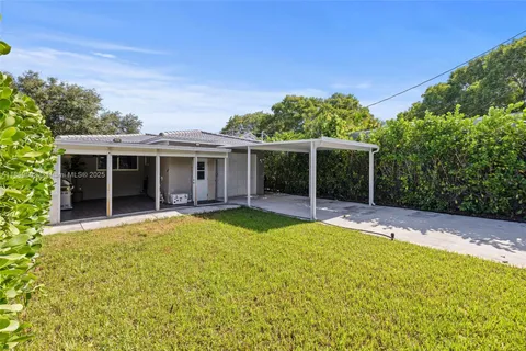 a view of a house with a yard and potted plants
